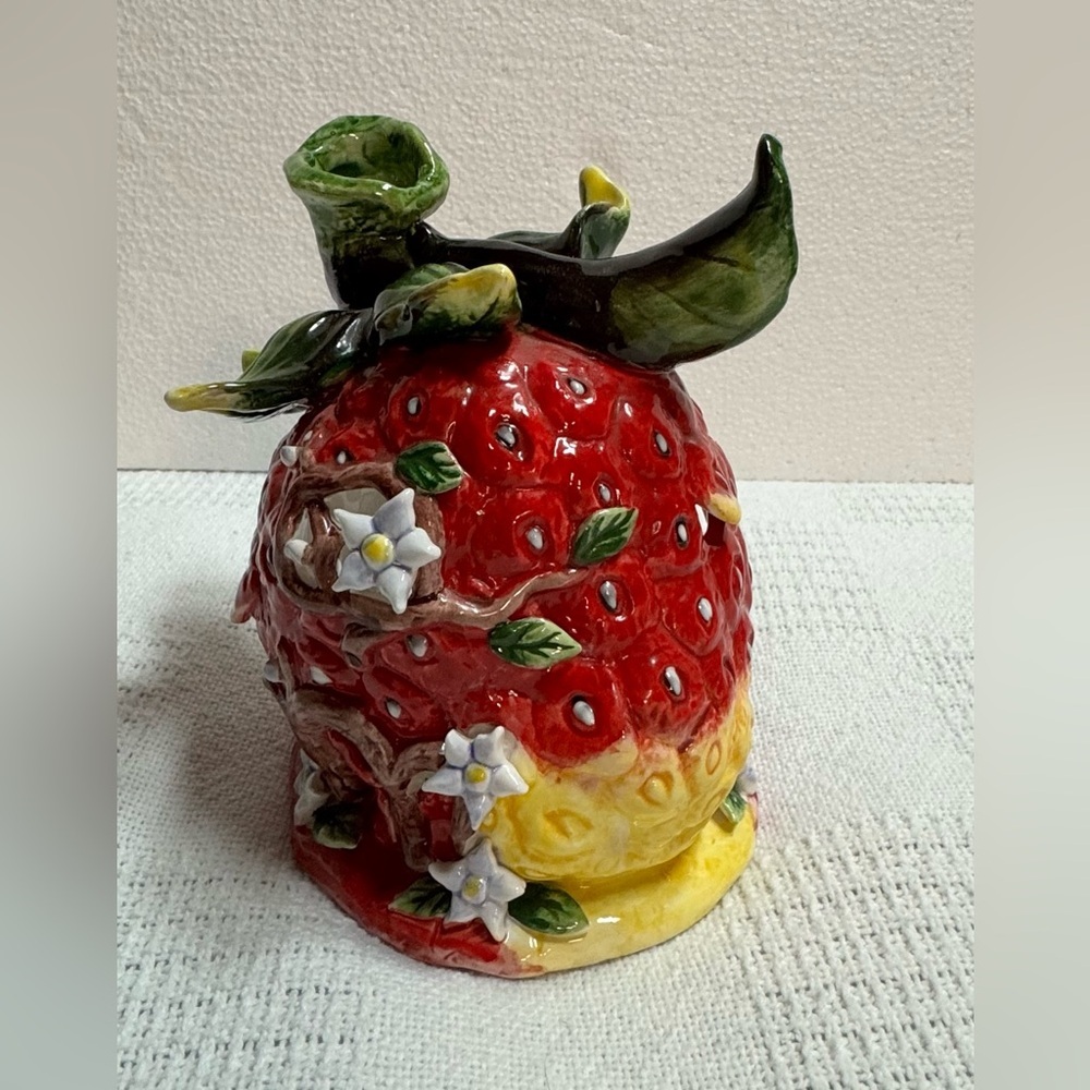 This is a vintage ceramic strawberry candle or tealight holder,